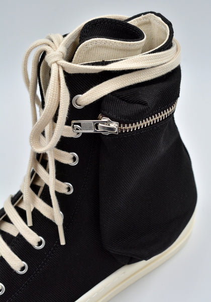 Cargo sneakers featuring a black cotton denim upper, above ankle height, eight eyelets, shoe lace, zipped cargo side pockets, milk white leather toe caps and shark tooth rubber soles